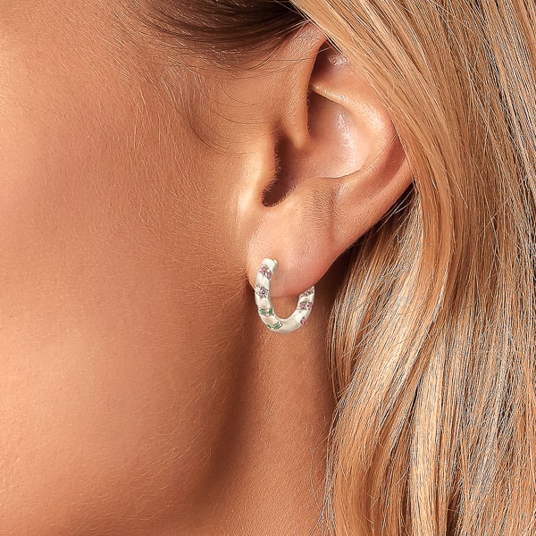 Woman wearing silver rainbow hoop earrings