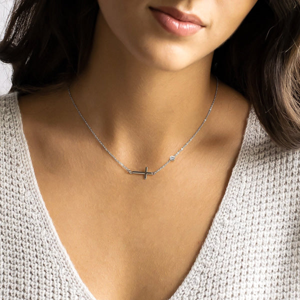 Woman wearing a silver sideways cross necklace