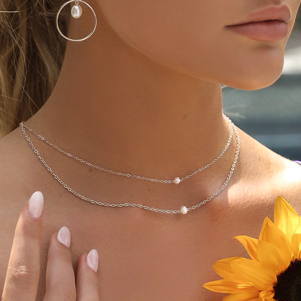 Two silver chain choker necklaces with one 4mm freshwater pearl on woman's neck