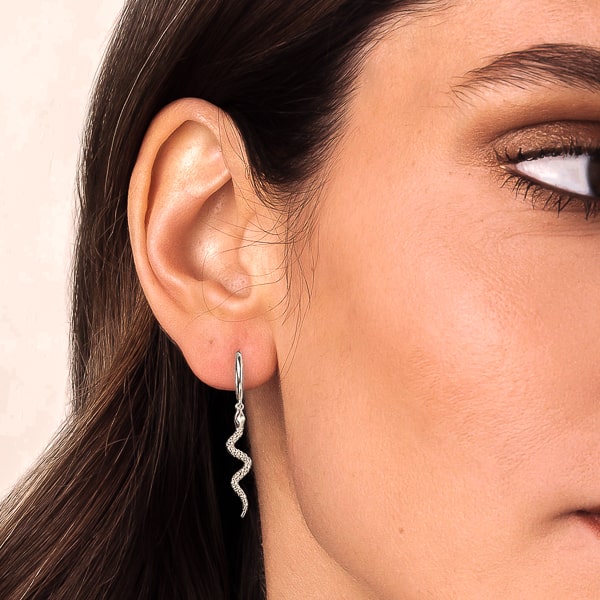 Model wearing silver snake drop earrings