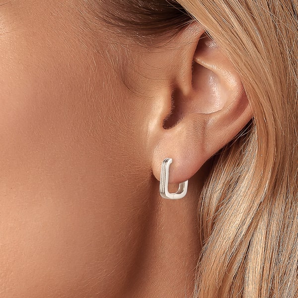 Woman wearing silver square hoop earrings