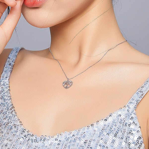 Woman wearing a silver tree of life heart pendant necklace