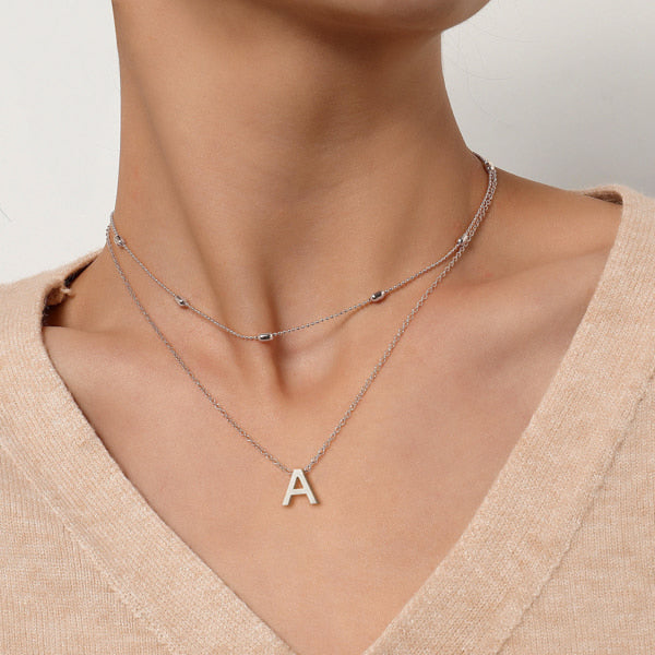 Woman wearing a simple silver initial necklace