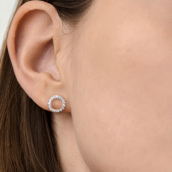 Woman wearing small silver cubic zirconia circle stud earrings