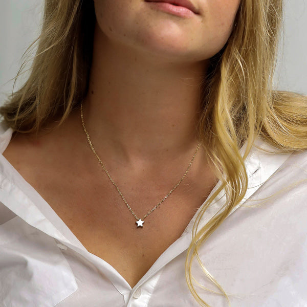 Woman wearing a small silver star necklace