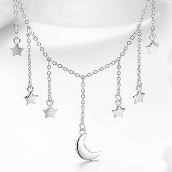 Moon and star charms dropping from a sterling silver choker necklace
