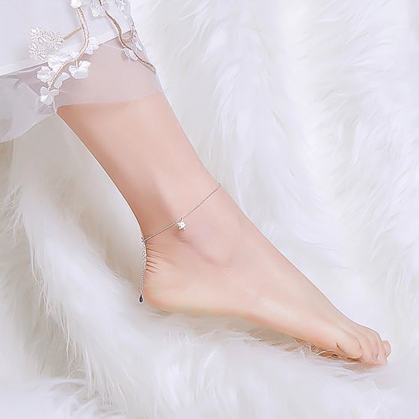 Silver star anklet on a womans ankle
