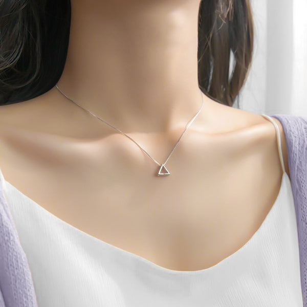 Woman wearing a silver triangle necklace