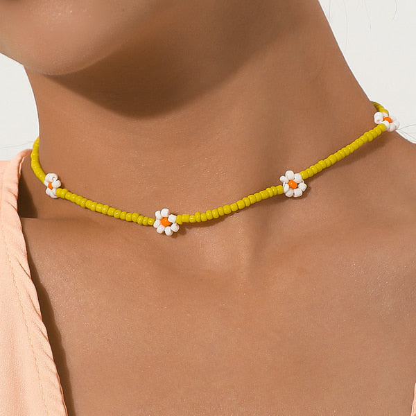 Woman wearing a yellow beaded daisy flower choker necklace