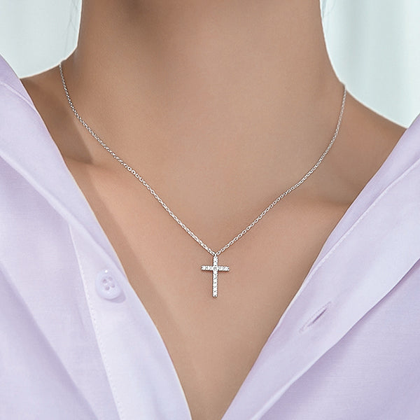 Woman wearing a silver crystal cross pendant necklace