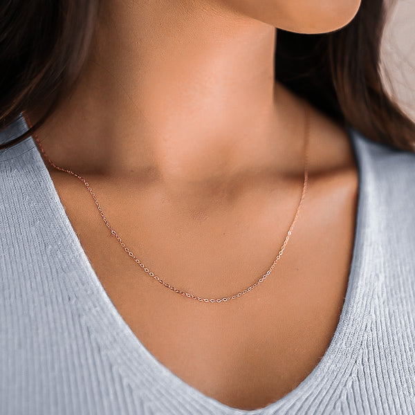 Woman wearing a 1.5mm rose gold cable chain necklace on her neck