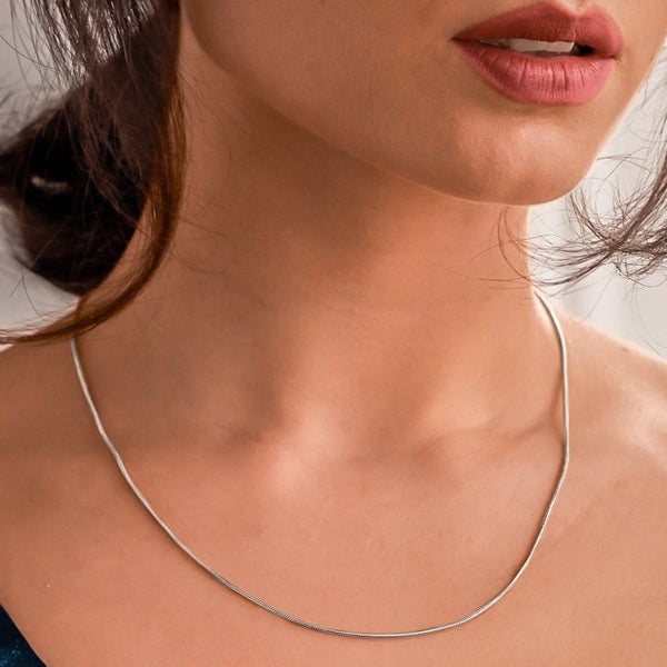 Woman wearing a thin 1.5mm silver snake chain necklace