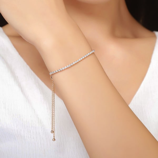 Gold tennis bracelet with an adjustable bolo closure on a woman's wrist