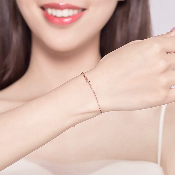 10K rose gold vermeil dual chain bracelet on a woman's wrist