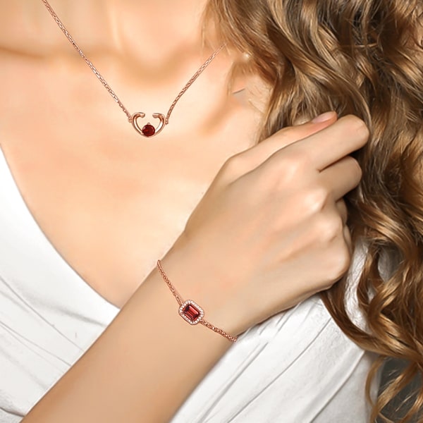 Rose gold vermeil bracelet with red emerald cut garnet on a woman's wrist
