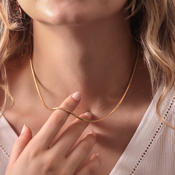 Woman wearing a 2.5mm gold snake chain necklace