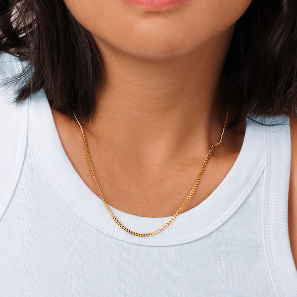 Woman wearing a thin 2mm gold curb chain necklace
