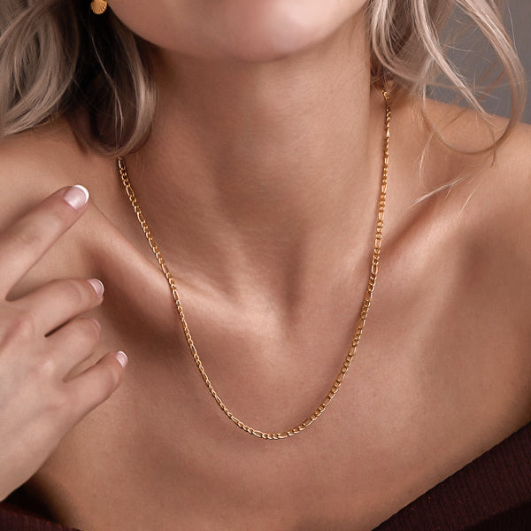 Woman wearing a 3mm gold figaro chain necklace