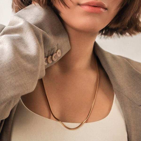 Woman wearing a thick 3mm gold snake chain necklace