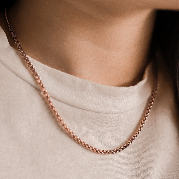 Woman wearing a 3mm rose gold wheat chain necklace
