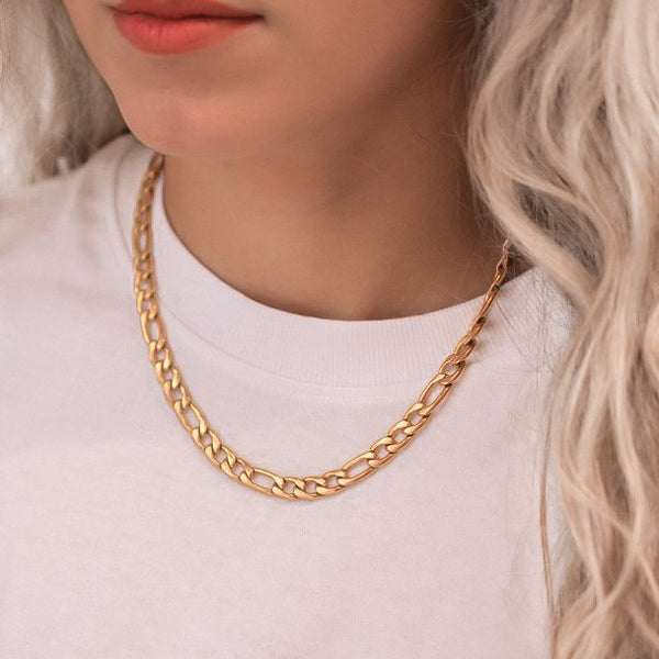 Woman wearing a 6mm gold figaro chain necklace