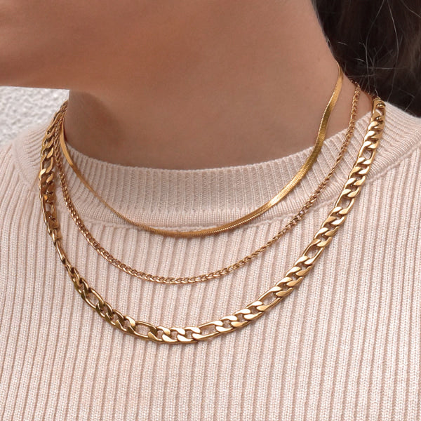 Woman wearing a 7.5mm gold figaro chain necklace