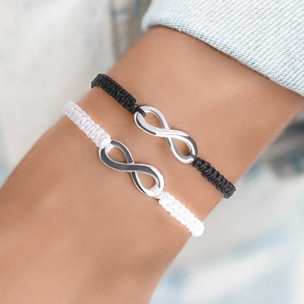 Woman wearing a black and white infinity bracelet set