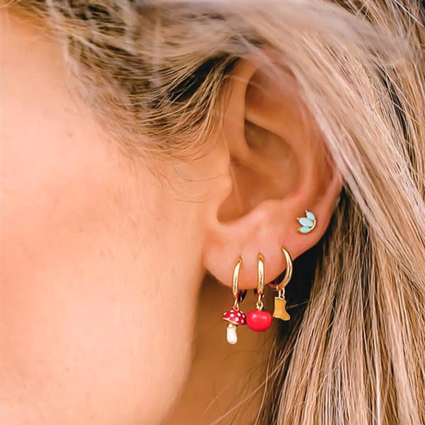 Woman wearing apple mini hoop drop earrings
