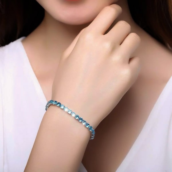Aquamarine blue cubic zirconia tennis bracelet on a woman's wrist