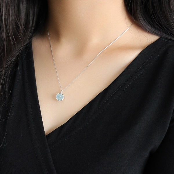 Woman wearing an aquamarine pendant necklace