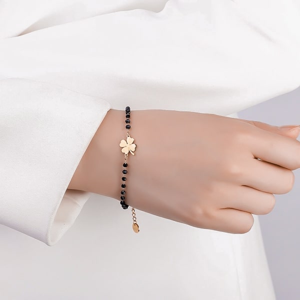 Woman wearing a black and gold beaded clover bracelet