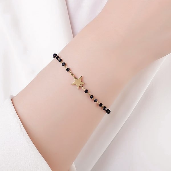 Woman wearing a black and gold beaded star bracelet