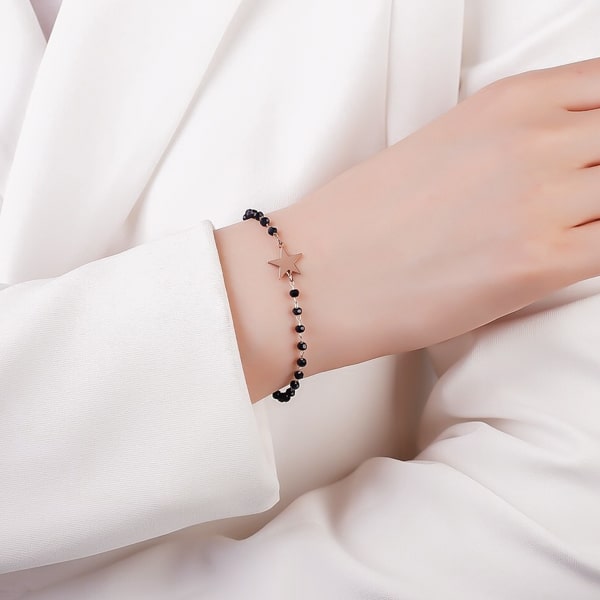 Woman wearing a black and rose gold beaded star bracelet