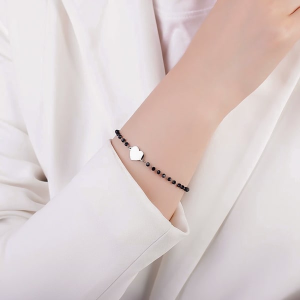 Woman wearing a black and silver beaded heart bracelet