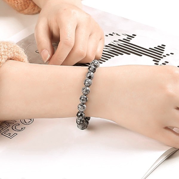 Beaded Snowflake Obsidian bracelet on a woman's wrist