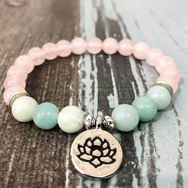 Beaded lotus flower charm bracelet displayed close up on a wooden background
