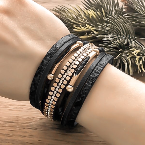 Woman wearing a black and gold snakeskin leather cuff bracelet on her wrist