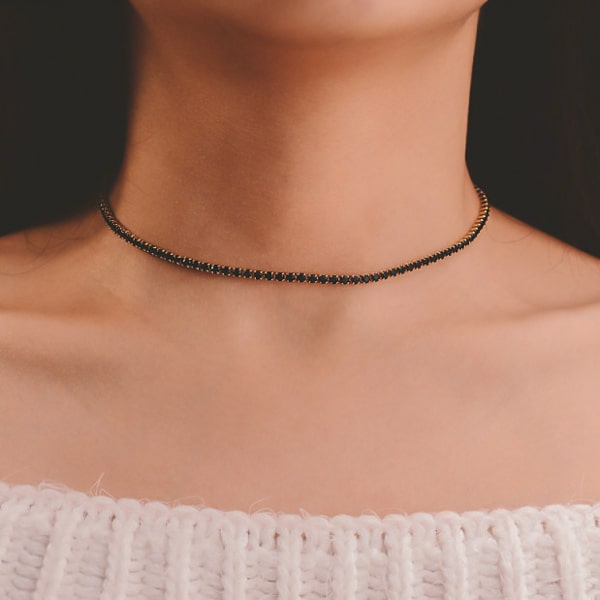 Woman wearing a black and gold tennis choker necklace