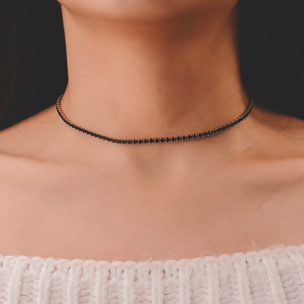 Woman wearing a black and silver tennis choker necklace