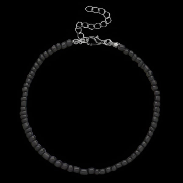 Black handmade beaded ankle bracelet on dark background