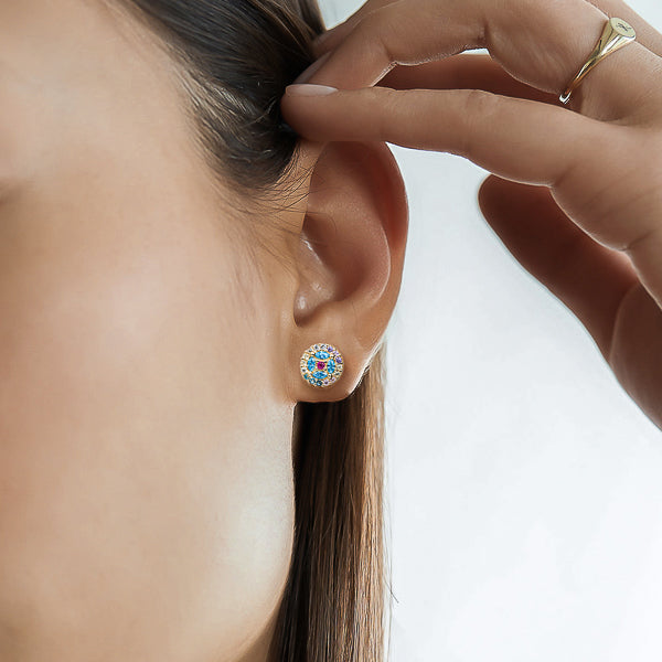 Woman wearing blue crystal pavé flower stud earrings