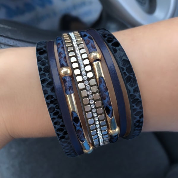 Woman wearing a blue and gold snakeskin leather cuff bracelet on her wrist