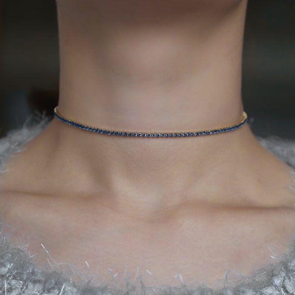 Woman wearing a blue and gold tennis choker necklace