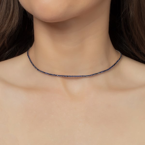 Woman wearing a blue and silver tennis choker necklace