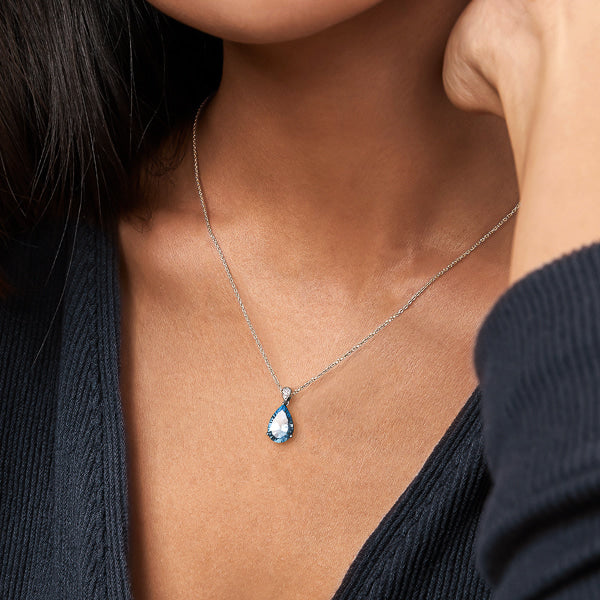 Woman wearing blue pear-cut Topaz necklace