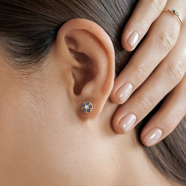 Blue crystal floral stud earrings on woman