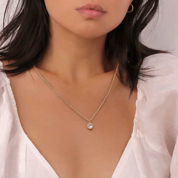Woman weating a classic gold crystal pendant necklace