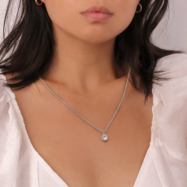 Woman wearing a classic silver crystal pendant necklace
