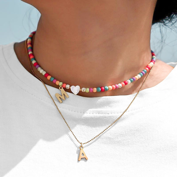 Woman wearing a colorful beaded initial letter choker necklace