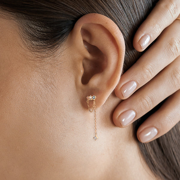 Woman wearing colorful cubic zirconia drop chain stud earrings